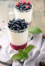 Delicious parfait dessert with bilberry, milk souffle and jello layers. Frozen treat in a glass on rustic wooden Royalty Free Stock Photo