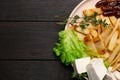 Delicious parsnip with lettuce, feta cheese and dates on black wooden table, top view. Space for text