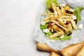 Delicious parsnip with lettuce, feta cheese and dates on white wooden table, flat lay. Space for text