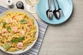Delicious pasta with shrimps, basil and parmesan cheese served on light wooden table, flat lay Royalty Free Stock Photo
