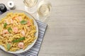 Delicious pasta with shrimps, basil and parmesan cheese served on light wooden table, flat lay. Space for text Royalty Free Stock Photo