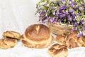 Delicious pastries bread and rolls with raisins and bouquet linen in wicker basket. Retro style