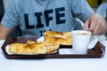 Delicious pastries with a mug of cocoa. A man sits in a cafe and dines