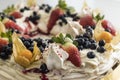 Delicious pavlova cake wreath of french meringue and whipped cream, decorated with strawberry, blueberries and physalis Royalty Free Stock Photo