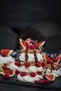 Delicious Pavlova meringue cakes decorated with chocolate cream, fresh figs and raspberries on dark background Royalty Free Stock Photo