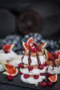 Delicious Pavlova meringue cakes decorated with chocolate cream, fresh figs and raspberries Royalty Free Stock Photo