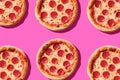 Delicious pepperoni pizzas arranged on vibrant pink background Royalty Free Stock Photo