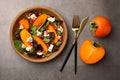 Delicious persimmon salad with cheese and pomegranate served on grey table, flat lay Royalty Free Stock Photo