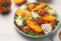 Delicious persimmon salad with cheese and pomegranate served on white table Royalty Free Stock Photo
