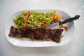 delicious peruvian flank steak dish accompanied with a green pesto pasta and vegetables Royalty Free Stock Photo