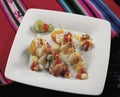 delicious peruvian food called Ceviche, raw fish cooked with lemon juice chili onion corn grains accompanied with Causa, plate on