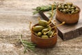 Delicious pickled capers and rosemary twigs on wooden table, closeup Royalty Free Stock Photo