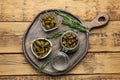 Delicious pickled capers and rosemary twigs on wooden table, top view Royalty Free Stock Photo