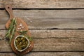 Delicious pickled capers and rosemary twigs on wooden table, top view. Space for text Royalty Free Stock Photo