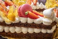 A delicious piece of torte with Meringues, cream, strawberries, and macaron. Royalty Free Stock Photo
