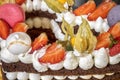 a delicious piece of torte with Meringues, cream, strawberries, and macaron. Royalty Free Stock Photo