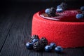 Delicious pink cake with berries on wooden table