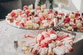 Delicious pink candy bar at wedding reception. Pink and white desserts,macarons and cupcakes on stand, modern sweet table at Royalty Free Stock Photo