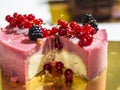 Delicious pink cheesecake with fresh berries on top, on a golden plate Royalty Free Stock Photo