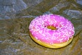 A delicious pink donut. Sweet donut with icing and sugar decoration. Object concept. Side view. Lying flat. Food concept. Macro