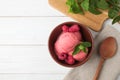 Delicious pink ice cream served with raspberries and mint in bowl on white wooden table, flat lay Royalty Free Stock Photo