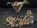 Pistachios are contained in a clear glass and placed on the table, with spring flowers Royalty Free Stock Photo