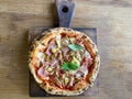 Delicious pizza Capriciosa consisting of tomatoes, Mozzarella cheese, ham, marinated mushrooms, artichoke, basil and butter. Pizza Royalty Free Stock Photo