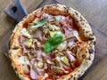 Delicious pizza Capriciosa consisting of tomatoes, Mozzarella cheese, ham, marinated mushrooms, artichoke, basil and butter. Pizza Royalty Free Stock Photo