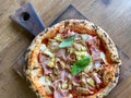 Delicious pizza Capriciosa consisting of tomatoes, Mozzarella cheese, ham, marinated mushrooms, artichoke, basil and butter. Pizza Royalty Free Stock Photo