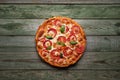 Delicious pizza with cheese and tomatoes on rustic wood table Royalty Free Stock Photo