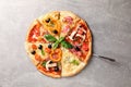 Delicious pizza with different pieces on grey background