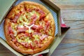 Delicious pizza with pineapple, ham slice, bacon slice, mozzarella cheese, pizza sauce in a delivery box