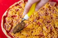 delicious pizza with sausage and cheese cut with a knife into pieces Royalty Free Stock Photo