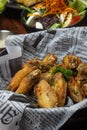 delicious plate of buffalo wings, with newspaper background
