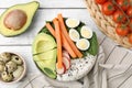 Delicious poke bowl and ingredients on white wooden table, flat lay