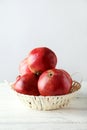 Delicious pomegranate fruit in basket on the white wooden background Royalty Free Stock Photo