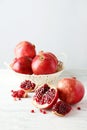 Delicious pomegranate fruit in basket on a white wooden background Royalty Free Stock Photo