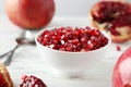Delicious pomegranate fruit in bowl on the white wooden background