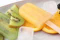 Delicious popsicle, ice cubes and fresh fruits on plate, closeup Royalty Free Stock Photo