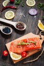 Delicious portion of fresh salmon fillet with aromatic herbs, spices and vegetables - healthy food, diet or cooking concept Royalty Free Stock Photo