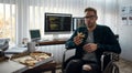 So delicious. Portrait of young hungry male web developer in a wheelchair eating pizza while sitting at his workplace in