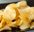 Delicious potato chips on the black plate Royalty Free Stock Photo