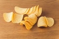 Delicious potato chips, laying on wooden table background