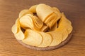 Delicious potato chips, laying on wooden table background