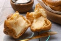 Delicious profiterole filled with cream on white tiled table, closeup