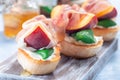 Delicious prosciutto peach bruschetta. Crostini, cream cheese, basil, peach, prosciutto, horizontal