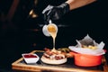 A delicious pub style bacon cheeseburger with barbecue sauce and french fries.The chef pours cheese sauce on the burger Royalty Free Stock Photo