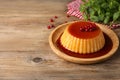 Delicious pudding with caramel and redcurrants on wooden table. Space for text