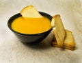 Delicious pumpkin pured soup with potatoes and zwiebacks bread slices. for vegetarian, vegan and healthy concept