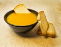 Delicious pumpkin pured soup with potatoes and zwiebacks bread slices. for vegetarian, vegan and healthy concept